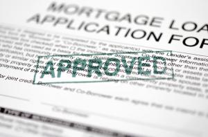 A green approved stamp on a mortgage application document