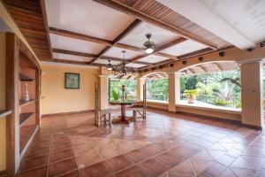 A sprawling 4,200 square foot villa with terracotta roof tiles and massive windows forms the heart of the tropical acreage.