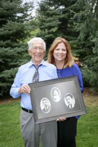 Holocaust survivor Joe Rubinstein, along with author Nancy Sprowell Geise, hold a photo of Joe's mother and two of his brothers, including Joe's identical twin (lower right). (Photo by Crystal Merril 2019)