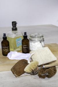 Photo shows 2 storage containers, 2 pipetter jars, a scrubbing brush and some cloths on a wooden table top