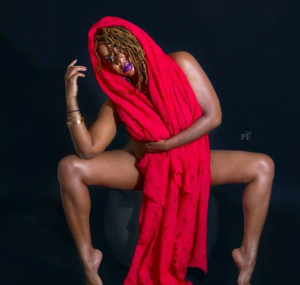 Betty Boo Banksta posing on a chair draped in red material.