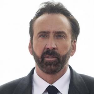 Color Photo of Nicholas Cage with beard, dressed in suit.