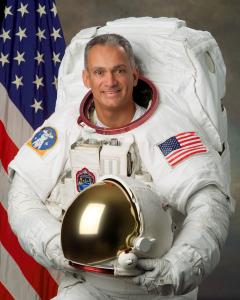 Today, on the 60th Anniversary of the first human to journey into outer space, Astronaut John “Danny” Olivas, Ph The official Astronaut portrait of Astronaut John "Danny" Olivas in his EVA (aka Spaceswalk) white suit holding his helmet (Photo Credit NASA)