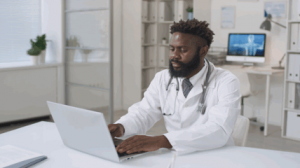 A doctor is typing on a keyboard in a modern medical clinic driven by digital health technology.