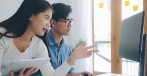 Developers collaborate while looking at a screen.