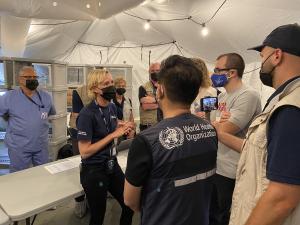 Assessors from the WHO ask International Medical Corps staff members questions during a tour of the EMT Type 1 facility.