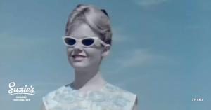 Archival 1950's photograph of a young, blond woman wearing retro sunglasses.