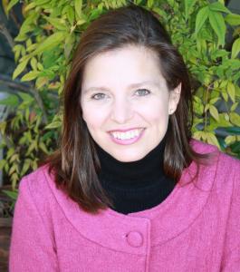 A woman with dark hair and a pink jacket