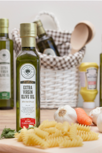 Artem Oliva's extra virgin olive oil is best for all types of hot or cold meals. This image is showing premium extra virgin olive oils in the kitchen with some pasta and garlic in the scene.
