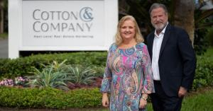 Laurie Andrews and Stephann Cotton stand in front of the Cotton & Company sign
