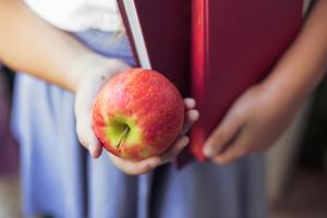 Back to School Nutrition – Tips from a Dietitian 1 child in school uniform holding apple