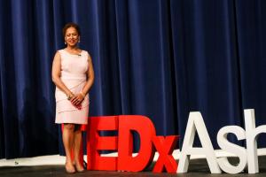 Tanja Thompson standing next to a 3D display that says TEDxAshburn after delivering her powerful TEDx Talk 