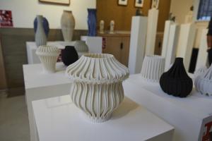 A series of white 3D printed clay vessels exhibited on pedestals during London Design Festival