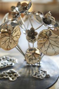 Table center piece in pewter with flowers and insects on sticks with base in stone