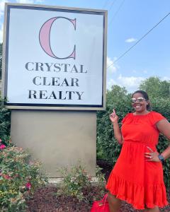 Crystal Swearingen with Crystal Clear Realty sign in front of her building