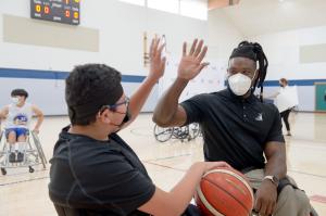 Matt Scott giving high five to a young adaptive athlete