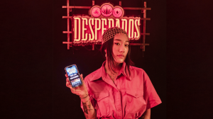 DJ Peggy Gou holding her phone with the Rave to Save app. The technology converts dance steps into donations for charities that champion inclusivity, and also unlock rewards the more you move
